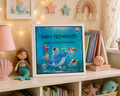 kindergarten friendship book 'Singing with Mermaids' displayed on children's shelf with cuddly toys, shells, fairy lights, lamp and books. early friendships, memories that matter